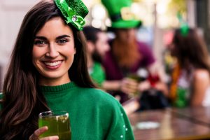Portrait of woman celebrating St Patricks day with friends and drinks